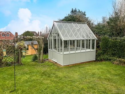 Crane Victoria Greenhouse A sage green Crane greenhouse in a large lawned garden